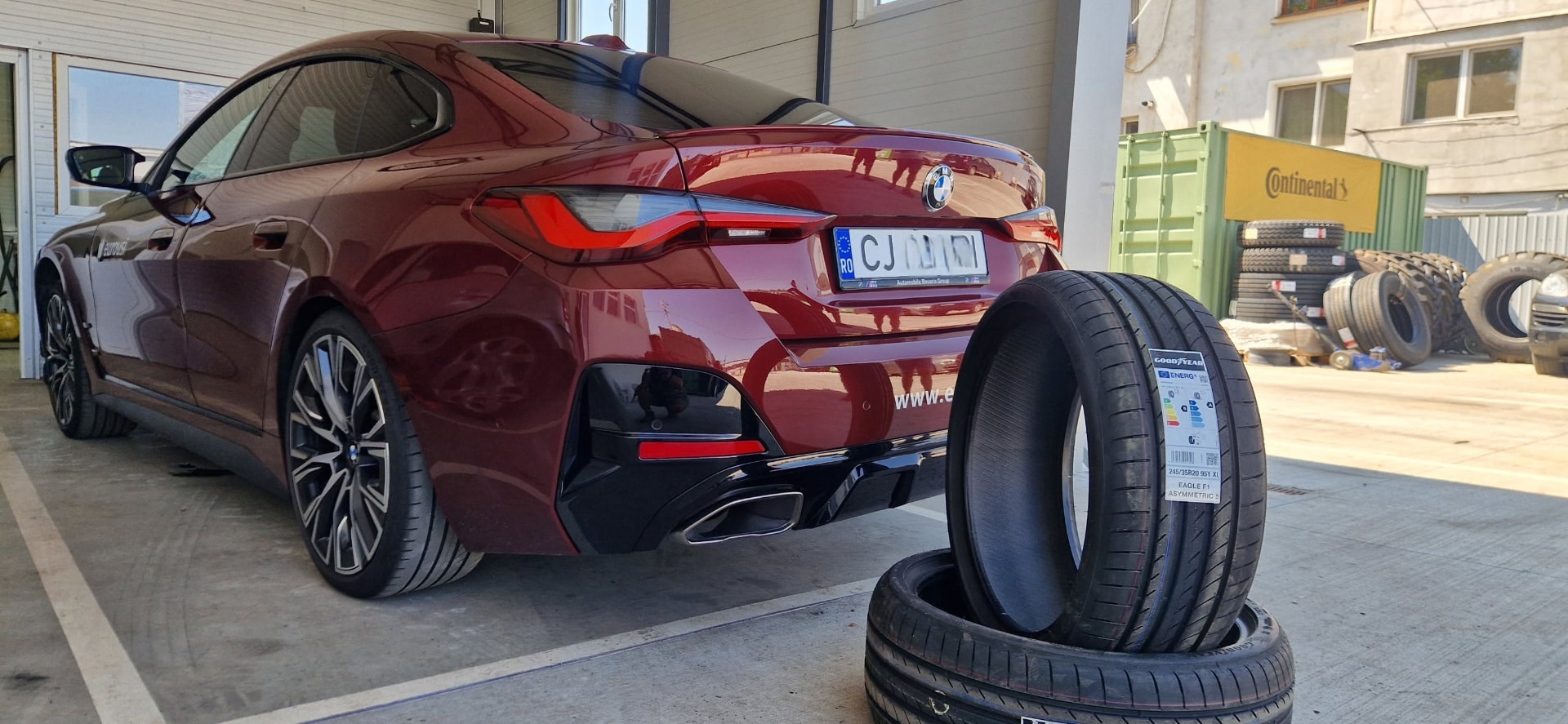 Autoturism BMW roșu cu anvelope noi în atelier
