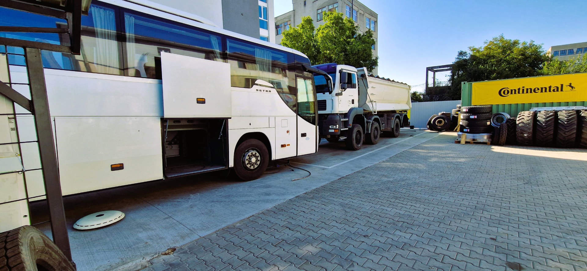 Autocar și camion în curtea atelierului